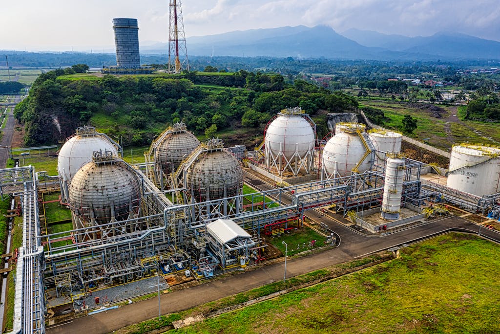 Aerial shot of a power plant with storage tanks in lush Banten, Indonesia offers an impressive scale.