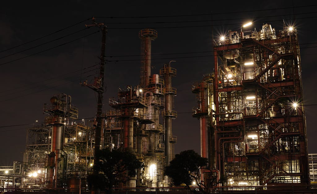 Night view of a brightly lit industrial facility showcasing intricate steel structures and machinery.