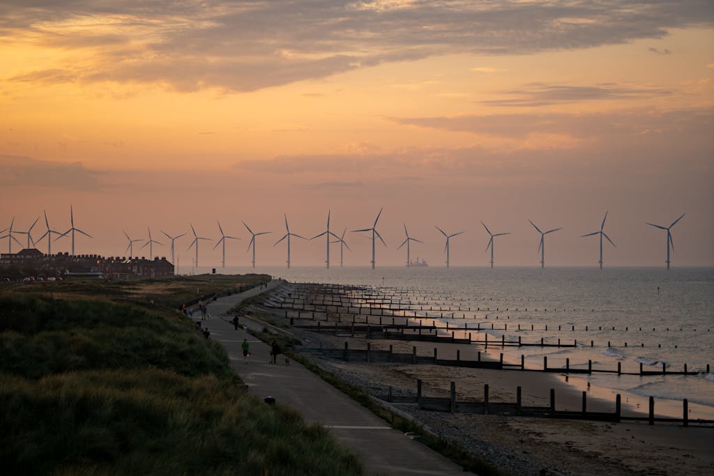 Scenic view of wind turbines and coastal pathway at sunset in York, England.